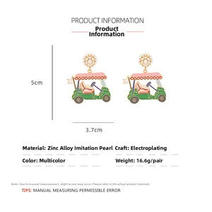 Detail of golf cart earrings featuring green enamel, pink roof, and faux pearls with dimensions