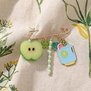 Detail of colorful fruit and wine glass pendant brooch with green apple and clover charms
