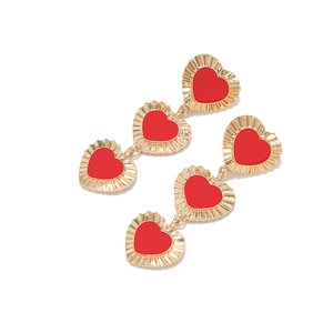 Orecchini pendenti chic placcati in oro con tre cuori in smalto rosso su sfondo bianco