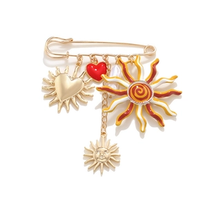 Golden sun and heart charms brooch with vintage bohemian design on white background