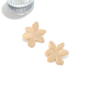 Detail of matte gold flower stud earrings featuring irregular petals and modern texture