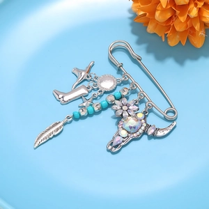 Detail of Western cowboy brooch with bull skull, feather, and boot charms on safety pin
