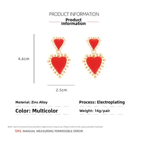 Detalle de pendientes de corazón rojo con cuentas doradas y chapado en aleación de zinc