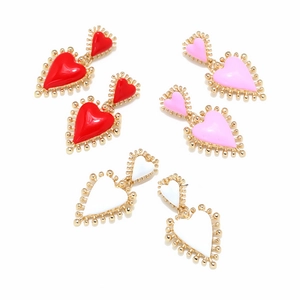 Detalle de pendientes de corazón multicapa con acabado en esmalte dorado y cuentas