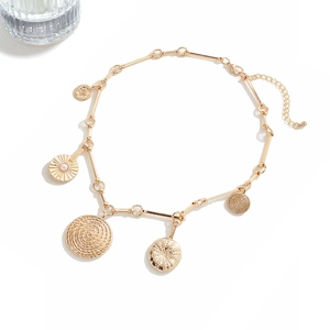 Detail view of gold coin pendants and link chain with faux pearl on white background