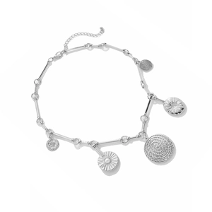Detail view of silver metal necklace with coin and sun pendants and lobster clasp