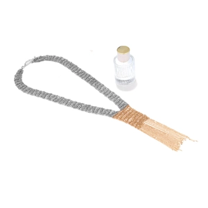 Detail of silver and gold multi-strand chain necklace with long metal fringe tassels