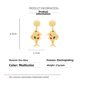 Detail view of long fishbone drop earrings in gold-plated alloy with multicolor enamel dots