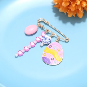 Detail of Easter brooch featuring colorful egg, heart charms, and blue floral ornament