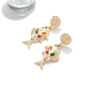 Detailed view of colorful enamel fish earrings with golden spiral studs on a white background