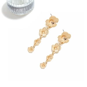 Close-up of golden tiered 3D flower tassel earrings with brushed metal petal textures
