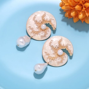 Detail of crescent enamel earrings with baroque pearl drops and golden texture on light blue