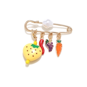 Detail of colorful fruit pendants and pearl on gold-tone safety pin brooch