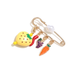 Detailed close-up of cute fruit and vegetable enamel charms on a golden safety pin brooch