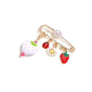 Detailed view of pins featuring strawberry, ladybug, and flower pendants with faux pearl