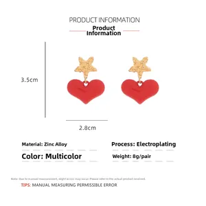 Detailed view of red heart earrings with gold star studs and size measurement