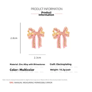 Detailed view of pink bow earrings with rhinestones showing dimensions 2.8cm by 2.3cm