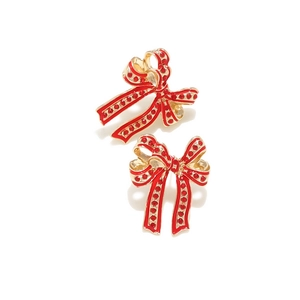 Close-up of elegant red enamel bow earrings with sparkling rhinestones on gold base