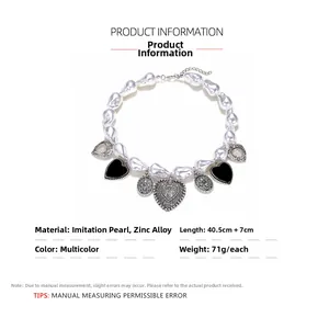 Vue détaillée du collier de perles baroques avec cœur en émail noir et pendentifs ajourés