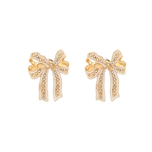 Detail of gold bow earrings with white enamel coating and shimmering crystal studs