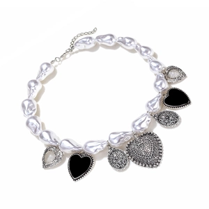 Détails de collier en perles baroques avec des cœurs en émail noir et breloques argent