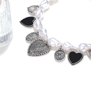 Collier de perles baroques avec breloques cœur argentées et pendentifs en émail noir