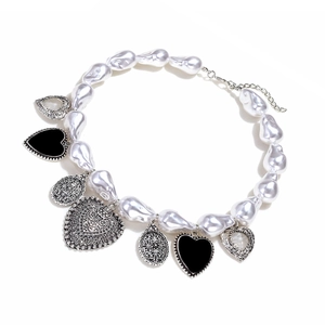 Détail du collier de perles baroques avec cœurs en émail noir et pendentifs ciselés
