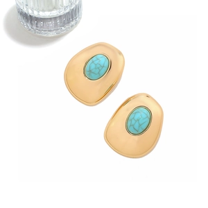 Detail view of vintage geometric gold earrings with turquoise inlay on white background