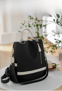 Détail du sac à dos en oxford imperméable bicolore avec poignées sur table blanche