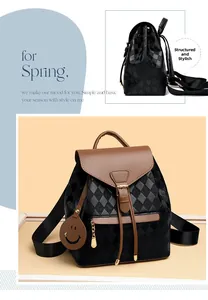 Detail view of the quilted black backpack featuring brown leather accents and side charm
