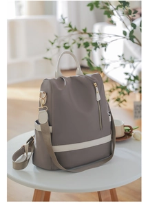 Détail du sac à dos en tissu oxford imperméable avec finitions dorées et poignée supérieure