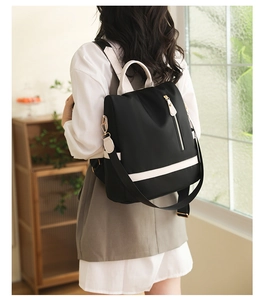 Détail du sac à dos en nylon imperméable avec sangles bicolores et zip doré chic