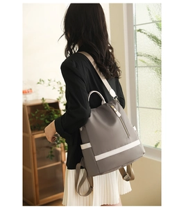 Détail du sac à dos en nylon imperméable avec boucles dorées et finition grise moderne