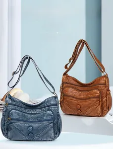 Detail of vintage washed leather messenger bags with multiple zippers and buckles
