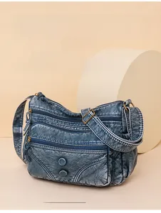 Detail of vintage denim blue washed leather messenger bag with multiple zipper pockets
