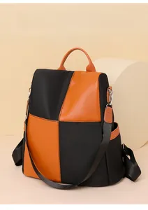 Detail of a casual bicolor backpack in black and orange with waterproof nylon and side pockets