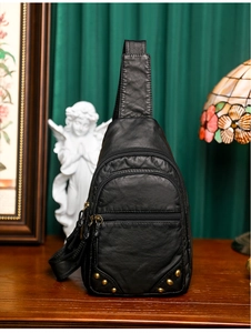 Détail du sac de poitrine en similicuir noir avec trois zips et rivets dorés rétro