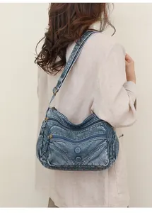 Macro shot of retro blue washed leather shoulder bag showing wide strap and zip pockets