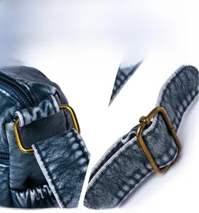 Detailed close-up of bronze metal hardware and vintage blue washed leather texture