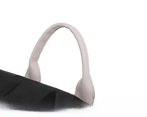 Détail de la poignée en similicuir rose et du tissu en nylon noir durable du sac à dos