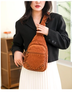 Détail d'un sac de poitrine en cuir PU marron vintage avec poches et rivets en laiton
