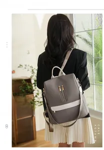 Vista posteriore di uno zaino oxford impermeabile grigio e bianco indossato da modella