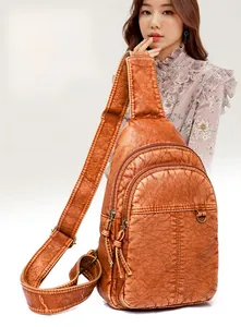 Detail der vintage karamellbraunen Brusttasche aus PU-Leder mit mehreren Reißverschlüssen