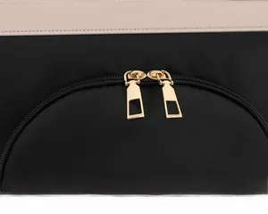 Vue détaillée des fermetures éclair dorées à double sens sur un sac en tissu noir robuste