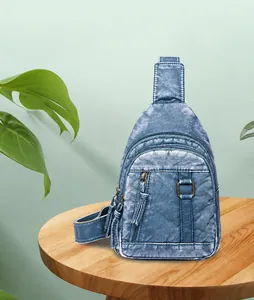 Detail of blue vintage PU leather chest bag with distressed texture and tassel zippers