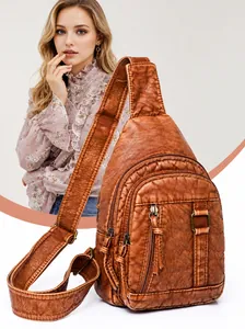 Macro detail of brown washed leather chest bag with functional metal zippers and multi-compartments