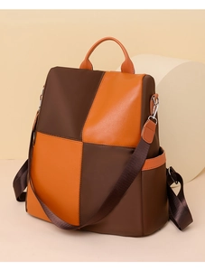 Detail of color-block backpack showing orange handle and brown waterproof nylon texture