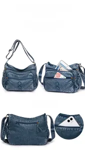 Detail view of large capacity blue washed leather crossbody bag with multiple zip pockets