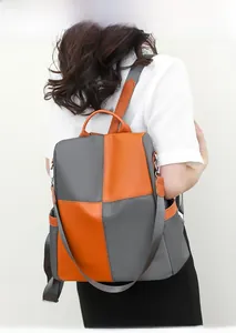 Detailed back view of a color-block backpack in vibrant orange and deep grey nylon