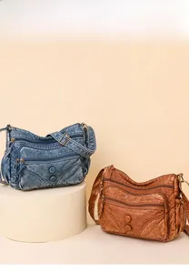 Close-up of vintage multi-zippered crossbody bags in blue denim and brown faux leather